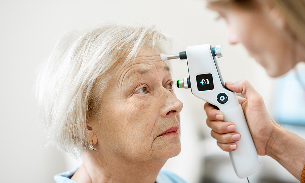 older woman getting cornea looked at during eye exam