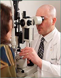 doctor using tool to look at patients cornea