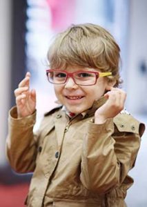 boy child trying on eyeglasses at optical center